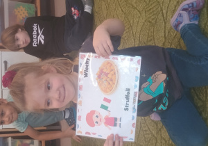 Dziewczynka prezentuje obrazek pączków i przysmaków w innych krajach