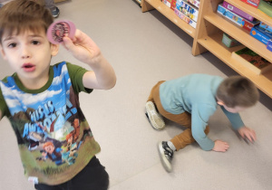 Chłopiec pokazuje znalezione obrazki pączków