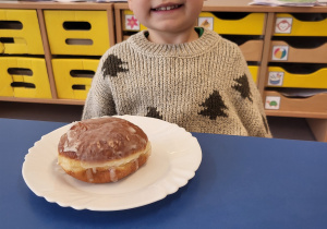 Chłopiec pozuje z pączkiem