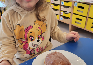 Dziewczynka pozuje z pączkiem