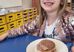 Dziewczynka pozuje z pączkiem