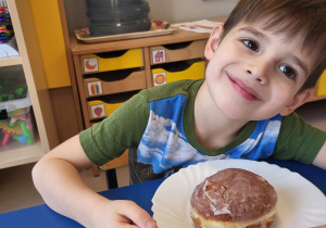 Chłopiec pozuje z pączkiem