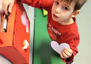 Chłopiec wrzuca wykonane przez siebie walentynki do skrzynki