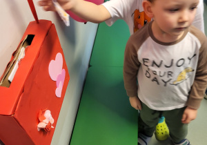 Chłopcy wrzucają wykonane przez siebie walentynki do skrzynki