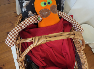 Maskotka kota w wiklinowym koszyku