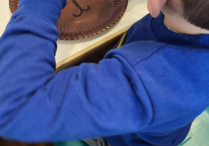 Chłopiec trzyma patyczek kosmetyczny w ręku