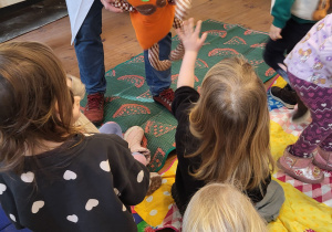 Dzieci przybijają piątkę pluszowemu kotkowi