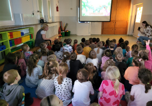 Dzieci oglądają film edukacyjny o dinozaurach