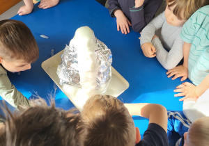 Dzieci obserwują pianę wylewającą się z wulkanu