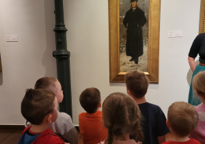 Dzieci patrzą na obraz mężczyzny w cylindrze