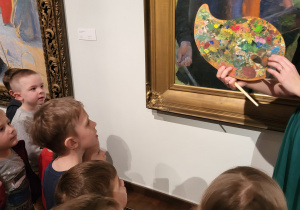 Dzieci patrzą na obraz oraz paletę malarską