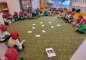 Dzieci siedzą w kole na dywanie