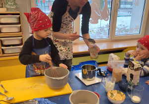Chłopiec ubija jajka, nauczycielka odmierza miód
