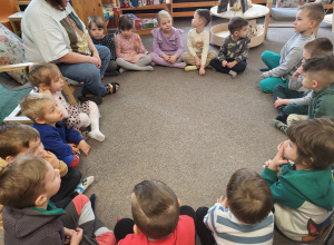 Dzieci siedzą w kole na dywanie