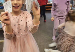 Dziewczynka pokazuje znalezione obrazki myszek