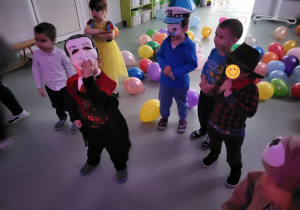 Dzieci stoją, dookoła leżą balony