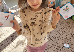 Dziewczynka pokazuje obrazki z rymami