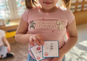 Dziewczynka pokazuje obrazki z rymami