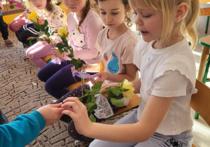 Dziewczynka odbiera żółtą różę od chłopca