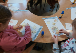 Dzieci przyklejają puzzle