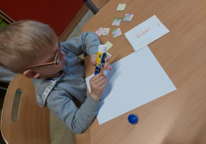 Chłopiec przykleja puzzle