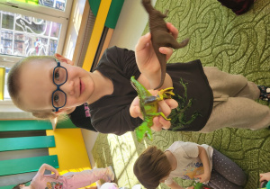Dzieci bawią się figurkami dinozaurów