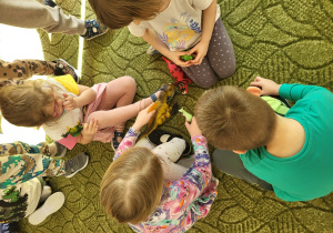 Dzieci bawią się figurkami dinozaurów