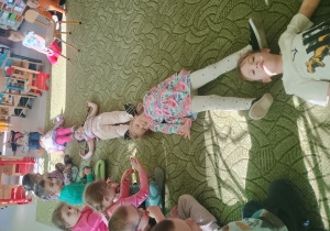 Dzieci mierzą długość szyi dinozaura