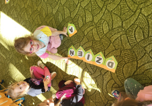 Dzieci układają napisz Dzień Dinozaura