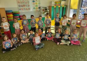 Dzieci z napisem Dzień Dinozaura