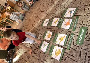 Chłopiec wskazuje kartę z dinozaurem