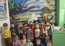 Dzieci pozują do zdjęcia na tle dekoracji Muminków