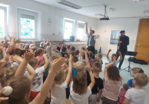 Dzieci wznoszą ręce podczas piosenki
