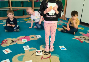 Dziewczynka trzyma w rękach ilustracje przedstawiającą postać z bajki