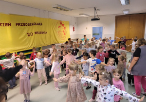 Dzieci wykonują ruchy do tańca prezentowane przez instruktora