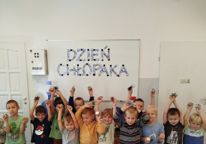 Chłopcy pozują pod tablicą z napisem ,,Dzień chłopaka''