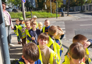 Dzieci stoją w parach obok skrzyżowania